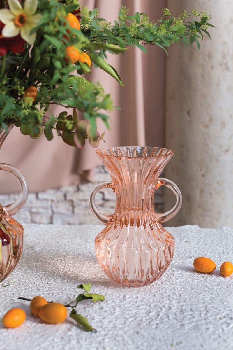mouth blown, with vertical ridges and a flared opening. Two curved handles show off an hourglass silhouette of this rosy hued containe