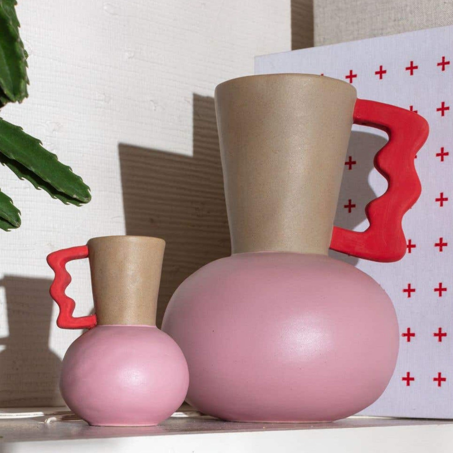 pitcher-silhouette and a distinctive three-toned design featuring soothing pink hues and bold red accents.