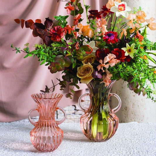 mouth blown, with vertical ridges and a flared opening. Two curved handles show off an hourglass silhouette of this rosy hued containe